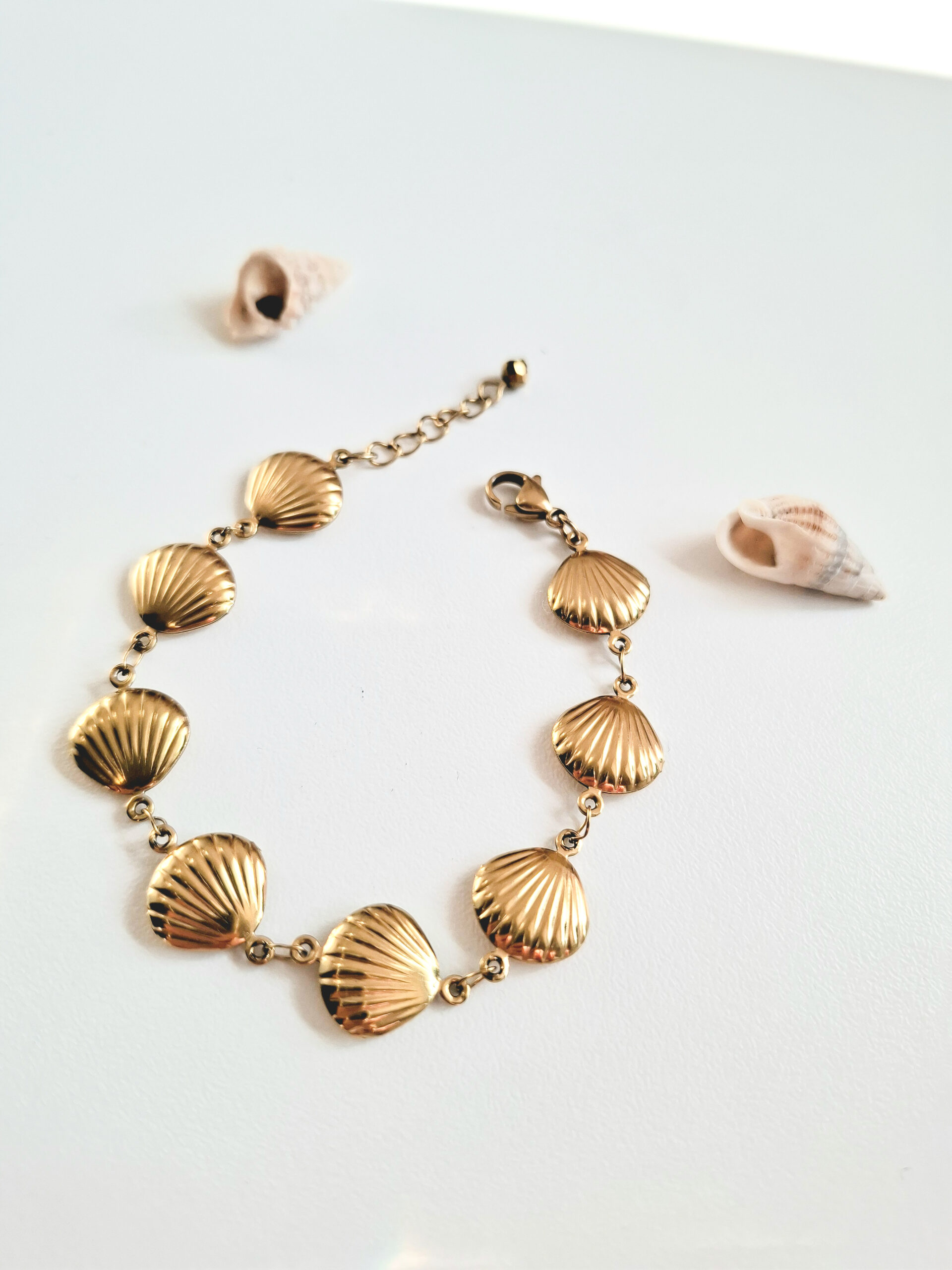un bracelet avec des coquillages dorés